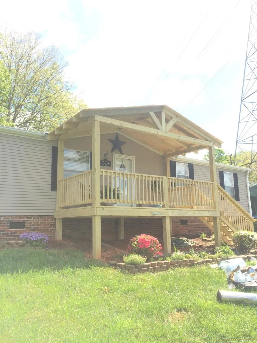New gabled porch roof and deck railing added to a ranch home in Mandaree